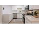 Bright kitchen featuring white cabinets, stainless steel appliances, and elegant marble-style countertops at 909 S Acapulco Ln # A, Tempe, AZ 85281