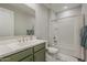 Bathroom with stylish green vanity, white countertop, and a shower-tub combo at 9352 E Saturn Ave, Mesa, AZ 85212