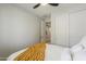 Bright, minimalist bedroom featuring a large window, ceiling fan, and closet with sliding doors at 9352 E Saturn Ave, Mesa, AZ 85212