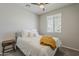 Serene bedroom with a ceiling fan, neutral walls, and a window that offers plenty of natural light at 9352 E Saturn Ave, Mesa, AZ 85212