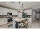 Inviting kitchen featuring stainless appliances, a center island with seating, and modern pendant lighting at 9352 E Saturn Ave, Mesa, AZ 85212