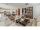 Open-concept living room featuring stylish decor, custom bookshelf, and seamless flow into the adjacent dining and kitchen areas at 9352 E Saturn Ave, Mesa, AZ 85212
