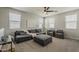 Spacious living room with plush seating, large windows, and a ceiling fan at 9352 E Saturn Ave, Mesa, AZ 85212