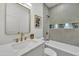 Updated bathroom with bright vanity, tile shower-tub, and a decorative mirror at 1001 N Nielson St, Gilbert, AZ 85234
