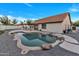 Backyard with a pool with rock waterfall, and outdoor kitchen area and ample patio space at 1001 N Nielson St, Gilbert, AZ 85234