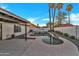 Backyard featuring a rock waterfall pool surrounded by gravel landscaping and palm trees at 1001 N Nielson St, Gilbert, AZ 85234