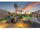 Cozy backyard with a firepit lounge area, ambient lighting, and mature desert landscaping at 10333 E Gold Nugget Ct, Gold Canyon, AZ 85118