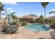 Beautiful backyard features a pool and an outdoor dining area shaded by a large umbrella, perfect for sunny days at 10333 E Gold Nugget Ct, Gold Canyon, AZ 85118
