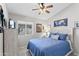 Bright bedroom featuring a cozy bed with blue bedding, a ceiling fan, and natural light from the window at 10333 E Gold Nugget Ct, Gold Canyon, AZ 85118