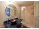 Modern bathroom with a spacious glass shower, vessel sink, and large, round mirror at 1040 E Osborn Rd # 501, Phoenix, AZ 85014