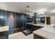 Modern bathroom with a glass-enclosed shower, dual sinks, large mirrors, and dark tile accents at 1040 E Osborn Rd # 501, Phoenix, AZ 85014