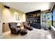 Elegant living room featuring leather armchairs, ottoman, built-in shelves, and a bright window at 1040 E Osborn Rd # 501, Phoenix, AZ 85014