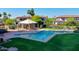 Community pool with ample seating, shaded area, lush grass, and nearby condominium residences at 1040 E Osborn Rd # 501, Phoenix, AZ 85014