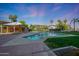 Community pool surrounded by lush landscaping and featuring covered lounge area for relaxing poolside at 1040 E Osborn Rd # 501, Phoenix, AZ 85014