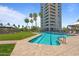Community pool with palm trees and lounge chairs in front of a high-rise condominium building on a sunny day at 1040 E Osborn Rd # 501, Phoenix, AZ 85014