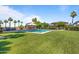 Community pool surrounded by lush green lawn, palm trees, and shaded seating at 1040 E Osborn Rd # 501, Phoenix, AZ 85014
