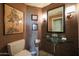 Unique powder room with framed artwork, glass vessel sink, and modern sconce lighting at 1040 E Osborn Rd # 501, Phoenix, AZ 85014