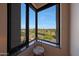 Scenic golf course view from a corner window with a comfortable chair at 1040 E Osborn Rd # 501, Phoenix, AZ 85014