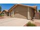 Front exterior showcasing the home's two-car garage and desert landscaping at 11206 W Sieno Pl, Avondale, AZ 85392