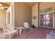 Inviting covered front porch with tiled flooring and decorative seating area at 11206 W Sieno Pl, Avondale, AZ 85392