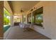 A covered back patio is furnished with a table and chairs beside a large hot tub at 11312 E Enrose St, Mesa, AZ 85207