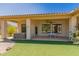 Covered back patio features a hot tub and an area with a table and chairs on artificial grass at 11312 E Enrose St, Mesa, AZ 85207