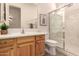 A bright bathroom with wood cabinets, marble countertop and a glass-door shower at 11312 E Enrose St, Mesa, AZ 85207