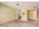 Open bedroom with neutral carpet, light green walls, and arched doorway at 11312 E Enrose St, Mesa, AZ 85207