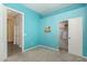 A bedroom with light blue walls leads into another room with carpeted floor and a closet with door at 11312 E Enrose St, Mesa, AZ 85207