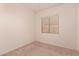 A bedroom with beige walls features a window with horizontal blinds and a carpeted floor at 11312 E Enrose St, Mesa, AZ 85207