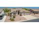Aerial front view of a home with desert landscape, a three car garage, and mountain views at 11312 E Enrose St, Mesa, AZ 85207