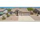Aerial front view of a home with a desert landscape and a three car garage at 11312 E Enrose St, Mesa, AZ 85207