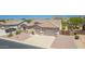 Aerial front view of a home with desert landscape, a three car garage and mountain views at 11312 E Enrose St, Mesa, AZ 85207