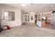 Open concept living room featuring carpet flooring, large windows, and sight lines to the kitchen at 11312 E Enrose St, Mesa, AZ 85207