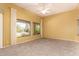 Spacious living room with neutral carpet, a ceiling fan, and multiple windows at 11312 E Enrose St, Mesa, AZ 85207
