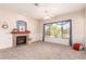 Spacious living room featuring a fireplace, neutral carpet, a ceiling fan, and a large window at 11312 E Enrose St, Mesa, AZ 85207