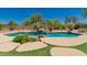 Inviting pool area with rock features, artificial grass, and desert plants at 11312 E Enrose St, Mesa, AZ 85207