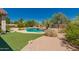 Backyard pool with lush desert landscaping, artificial grass, and rock features at 11312 E Enrose St, Mesa, AZ 85207