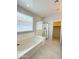 Primary bathroom features large tub, shower with glass door, and door to walk-in closet at 1241 E Palo Verde Dr, Casa Grande, AZ 85122