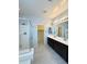Bright bathroom boasts a dual sink vanity, large mirrors and walk-in shower with glass door at 1241 E Palo Verde Dr, Casa Grande, AZ 85122