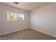 Bright bedroom featuring a window view and neutral carpet at 1310 E Ironwood Dr, Buckeye, AZ 85326