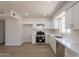 Updated kitchen features sleek white cabinets, stainless steel appliances, and new laminate flooring at 1310 E Ironwood Dr, Buckeye, AZ 85326