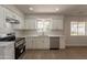 Updated kitchen features modern white cabinets, stainless steel appliances, and new laminate flooring at 1310 E Ironwood Dr, Buckeye, AZ 85326