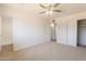Bright bedroom features ceiling fan, closet and an attached bathroom with a tiled shower at 1310 E Ironwood Dr, Buckeye, AZ 85326