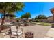 Outdoor seating area with a firepit and an umbrella-covered table overlooking the pool and surrounding landscape at 1405 E Aloe Dr, Chandler, AZ 85286