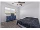 Bedroom with a dark gray accent furniture, a ceiling fan, and natural light from the large window at 1405 E Aloe Dr, Chandler, AZ 85286