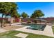 Backyard pool with desert landscape, block wall and a patch of green grass adding a touch of natural beauty at 1405 E Aloe Dr, Chandler, AZ 85286