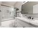 Bathroom with white marble walls, frameless shower, and modern fixtures at 1411 E Orangewood Ave # 233, Phoenix, AZ 85020