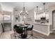 Dining area features modern chandelier and view into the stylish kitchen at 1411 E Orangewood Ave # 233, Phoenix, AZ 85020
