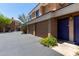 Condo exterior features attached garages, blue front door, and well maintained landscaping at 1411 E Orangewood Ave # 233, Phoenix, AZ 85020